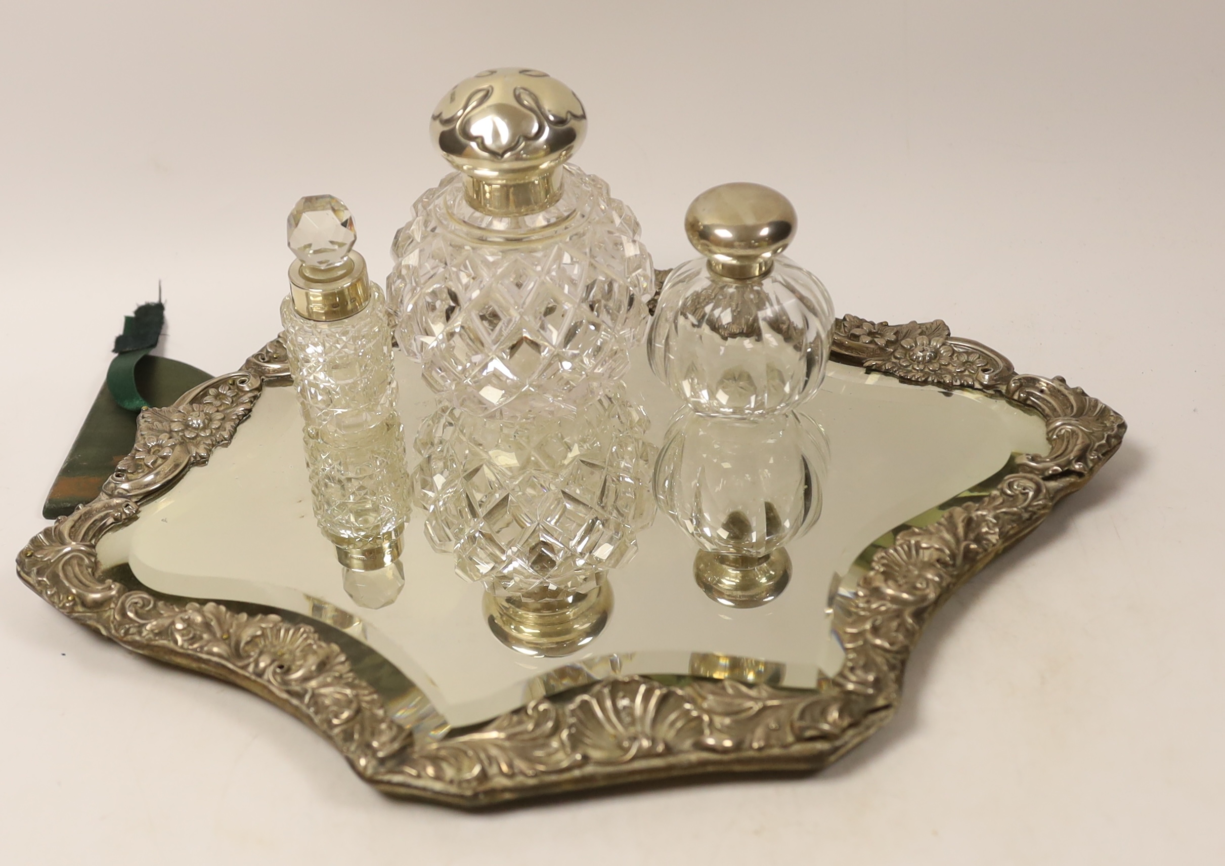 An Edwardian silver mounted easel mirror, Sheffield, 1902 (a.f.), together with three assorted silver mounted glass scent bottles.